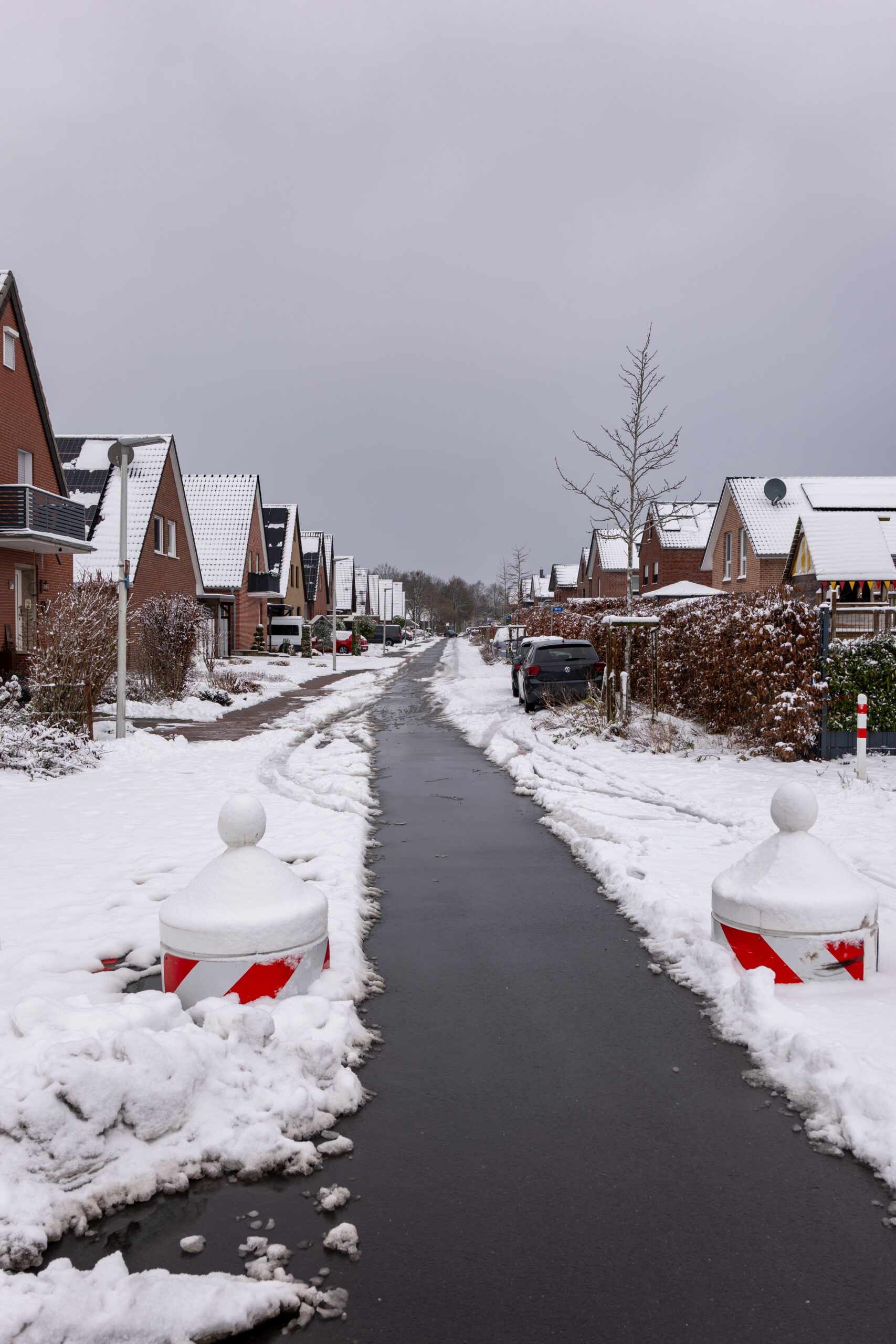 Geräumter Gehweg in verschneiter Wohnstraße